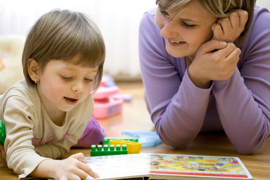 Mutter und Kind haben Spaß beim gemeinsamen Lernen und Spielen. Sie lesen ein Bilderbuch.