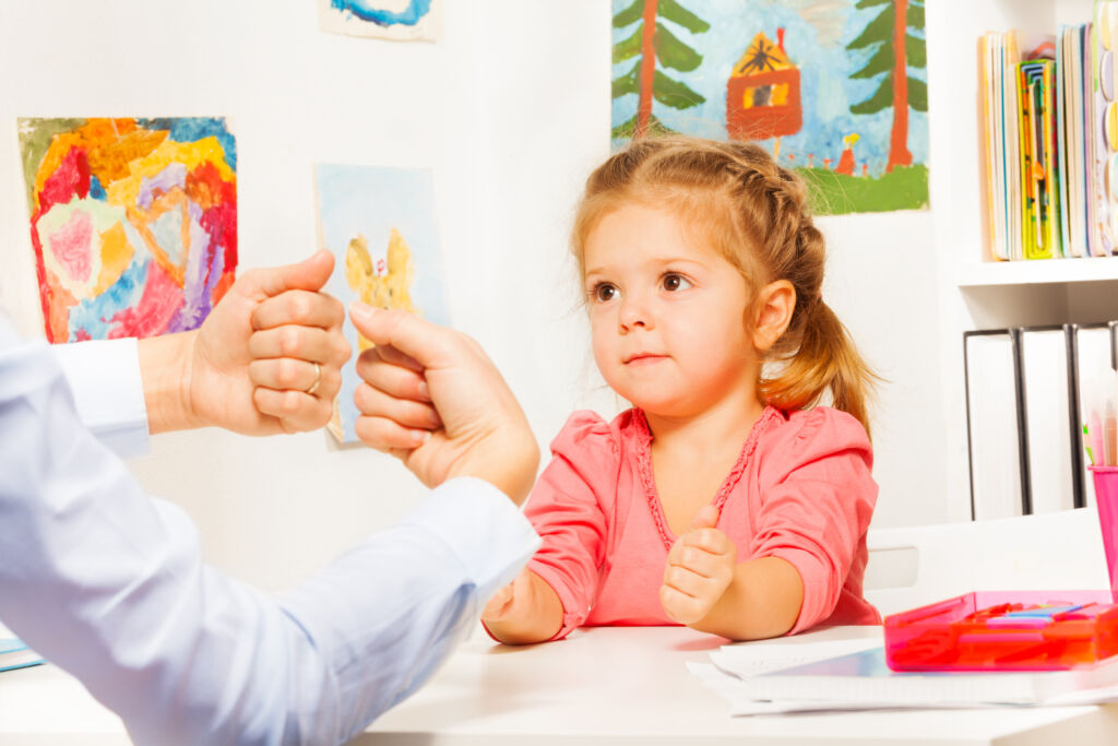 Kleine Mädchen spielt mit Lehrer